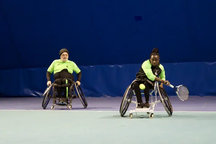 Due tenniste in carrozzina in campo.